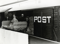 168575 Afbeelding van het overladen van post in een daarvoor bestemde gesloten goederenwagen van de N.S.
